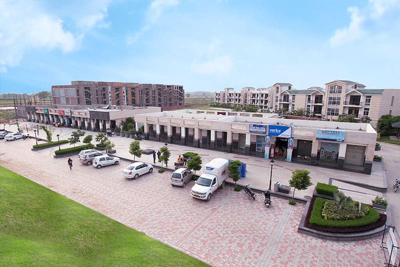 Omaxe Clockton High Street commercial project in New Chandigarh with landscaped plaza, retail shops, and office spaces on Beacon Street.